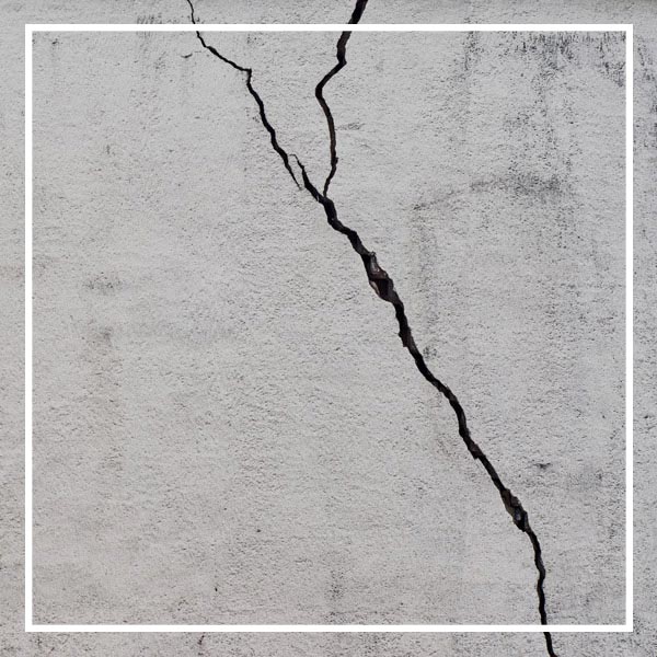 Cracked concrete walls indicate warning signs of foundation damage in Dallas