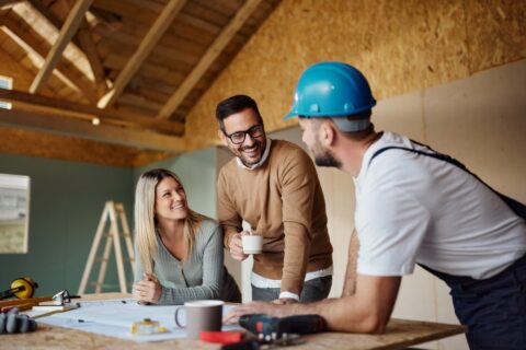 Couple talking about their home with construction worker