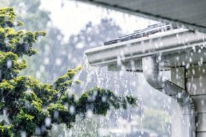 Heavy rain pouring off a home's gutter system in Dallas, TX 