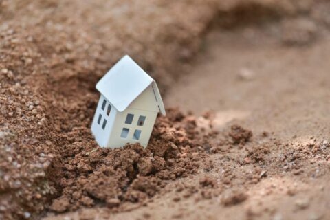 Miniature house eroding on a soil in in Dallas, TX