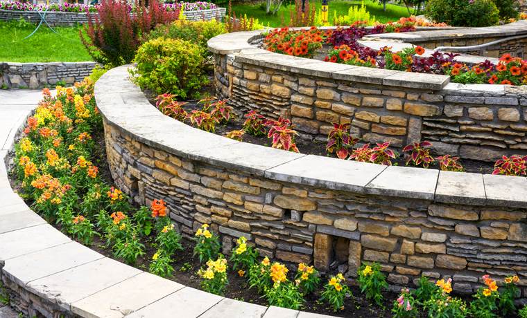 Curved stone retaining walls with colorful flowers in Dallas, TX