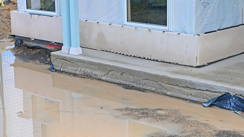 Construction site with flooded foundation and water pooling in Dallas, TX