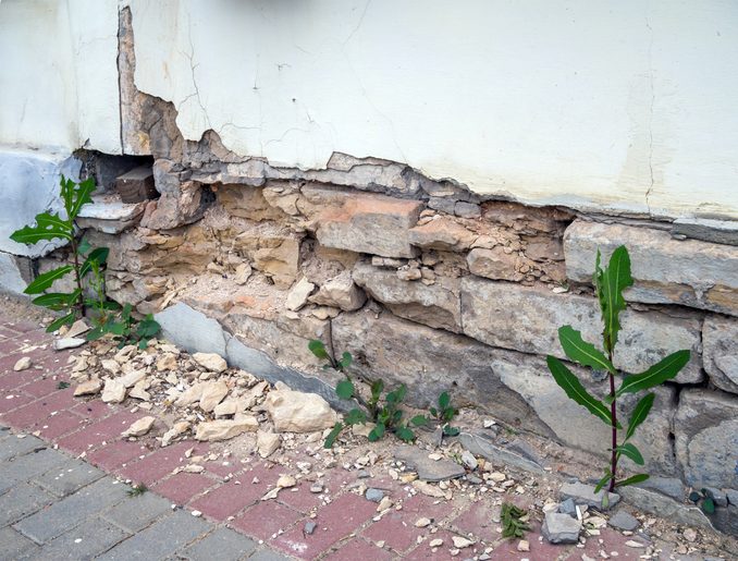 Damaged stone foundation with crumbling wall and cracks in Dallas, TX